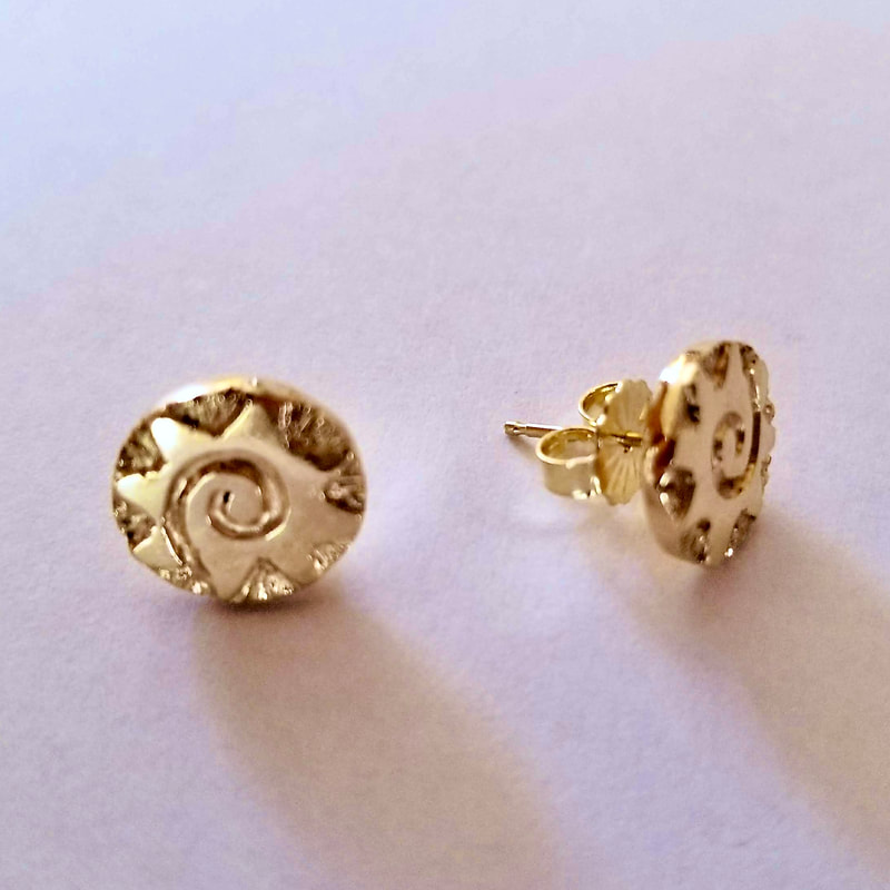 Gold round stud earrings with a spiral pattern.