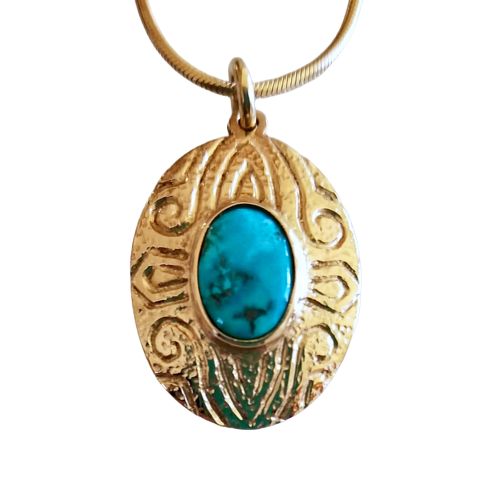 Patterned gold pendant with an oval Turquoise in the center.