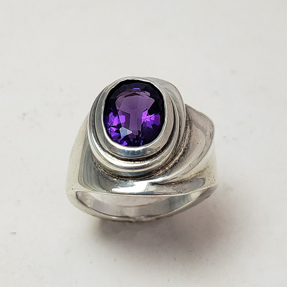 Sterling Silver ring with one oval shaped Amethyst in the center.