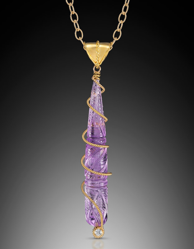 18 Karat Yellow Gold pendant with a triangular bail, carved Amethyst drop and a gold wire wrapping around it.