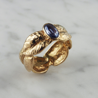 14 Karat Yellow Gold sculpted leaf band with a Sapphire in the center.