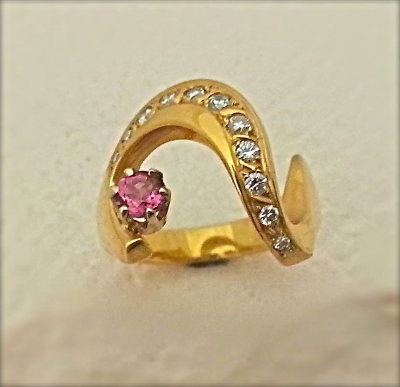 18 Karat Yellow Gold curved ring with a Pink Tourmaline and diamonds.