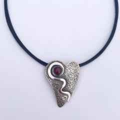 Sterling Silver heart shaped pendant with a round garnet.