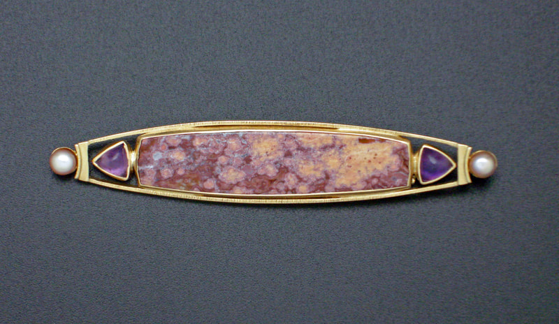18 Karat Yellow Gold elongated Agate with trillion shaped amethysts on each end and small pearls.
