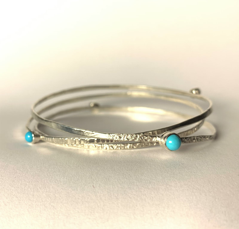 Sterling silver three bangle set with scattered bezel set round turquoise.