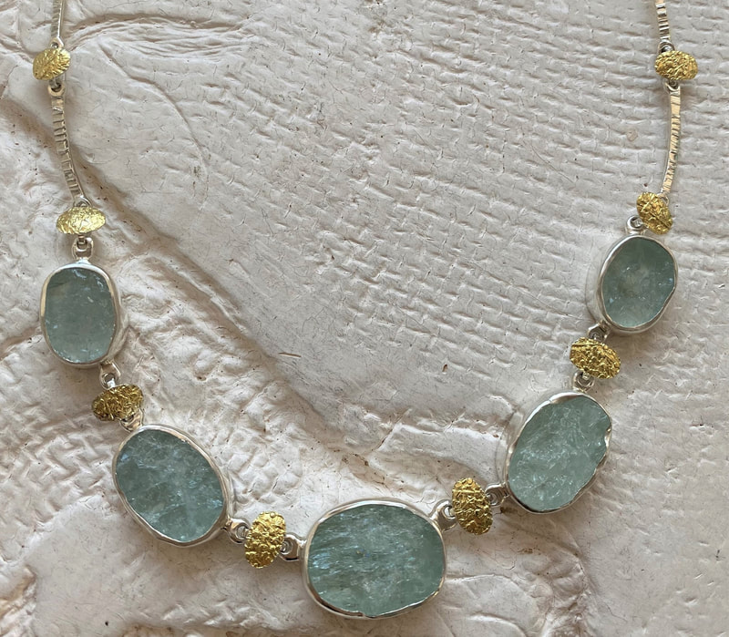 Silver and 22 Karat Yellow Gold Bi-Metal link necklace with oval natural face aquamarines.