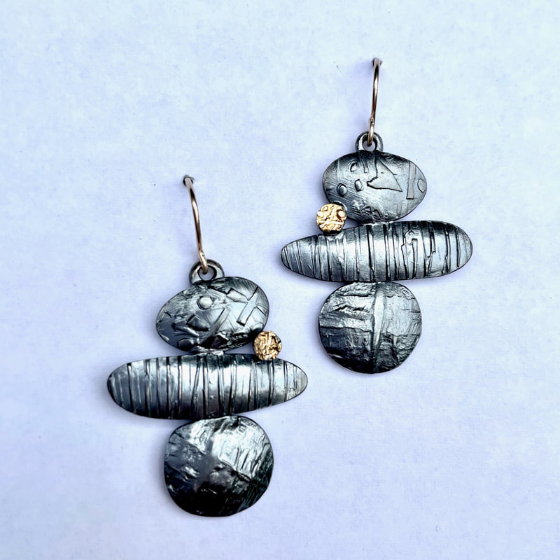 Oxidized silver different shaped textured French wire earrings with one small round 22 Karat Yellow Gold accent.