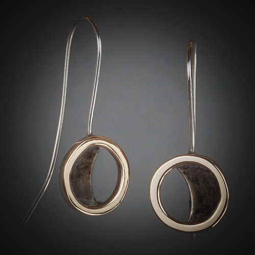 Silver wire earrings with 18 Karat Yellow gold circles and a blackened silver moon shape in the center.