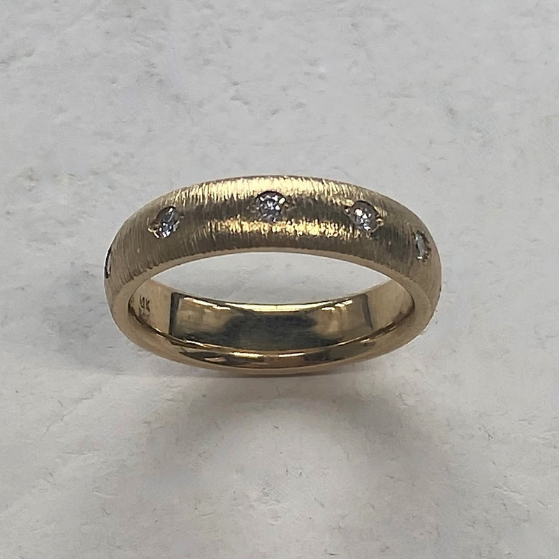Yellow gold domed, textured band with spaced inset diamonds all the way around.