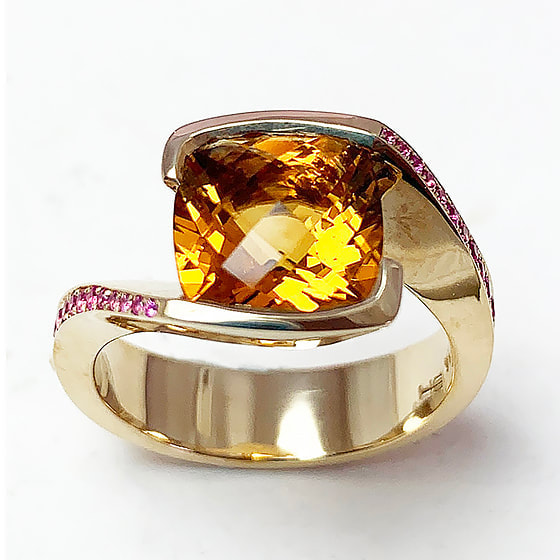 14 Karat Yellow Gold bypass ring with a cushion shaped citrine with Pink Sapphires down each side.