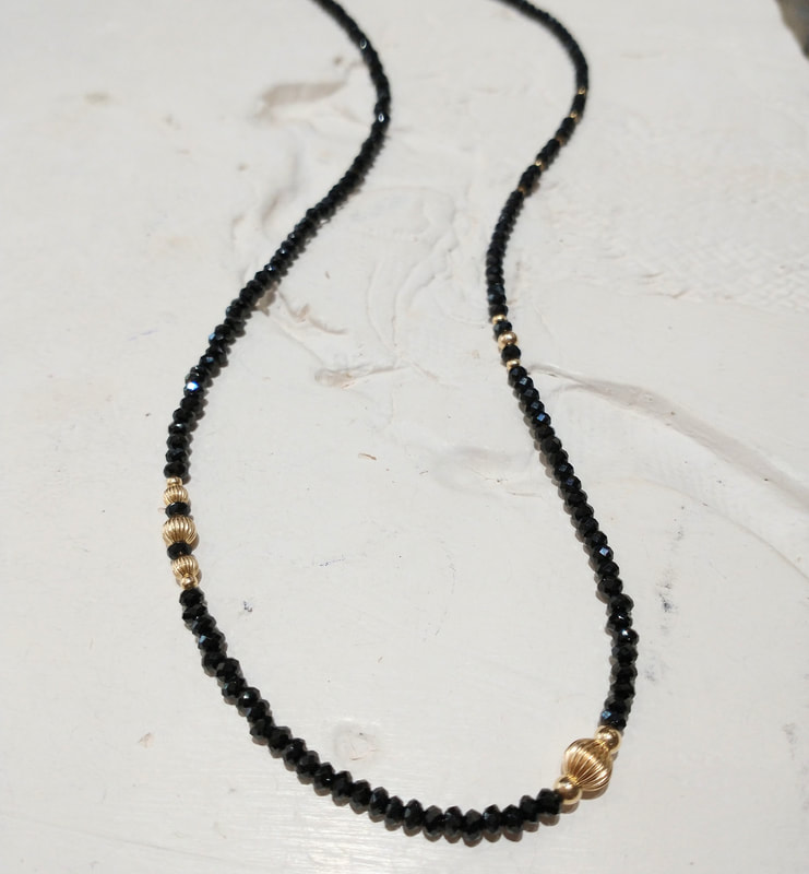 Gold beaded black Spinel necklace with gold beads scattered through it.