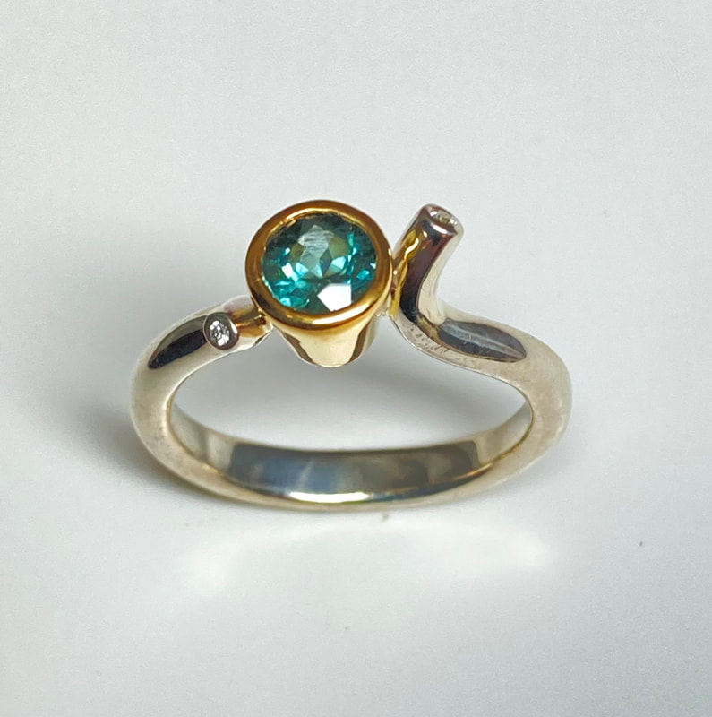 Sterling Silver and 18 Karat Yellow Gold ring with a bezel set Round Green Tourmaline & Diamonds..