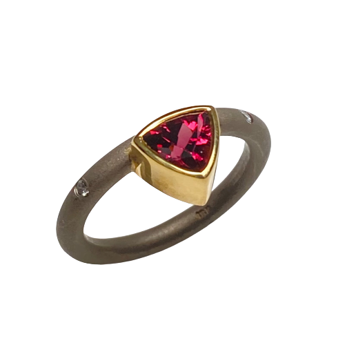 18 Karat Yellow and White Gold ring with darkened band with flush set diamonds and one off-set Trillian shaped Pink Tourmaline.