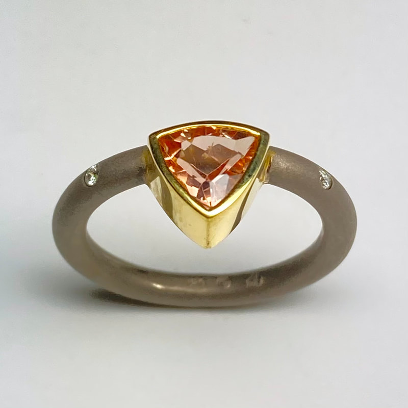 18 Karat Yellow & 18 Karat White Gold Ring with one off-set trillion shaped Precious Topaz & flush-set Diamonds  on the band.