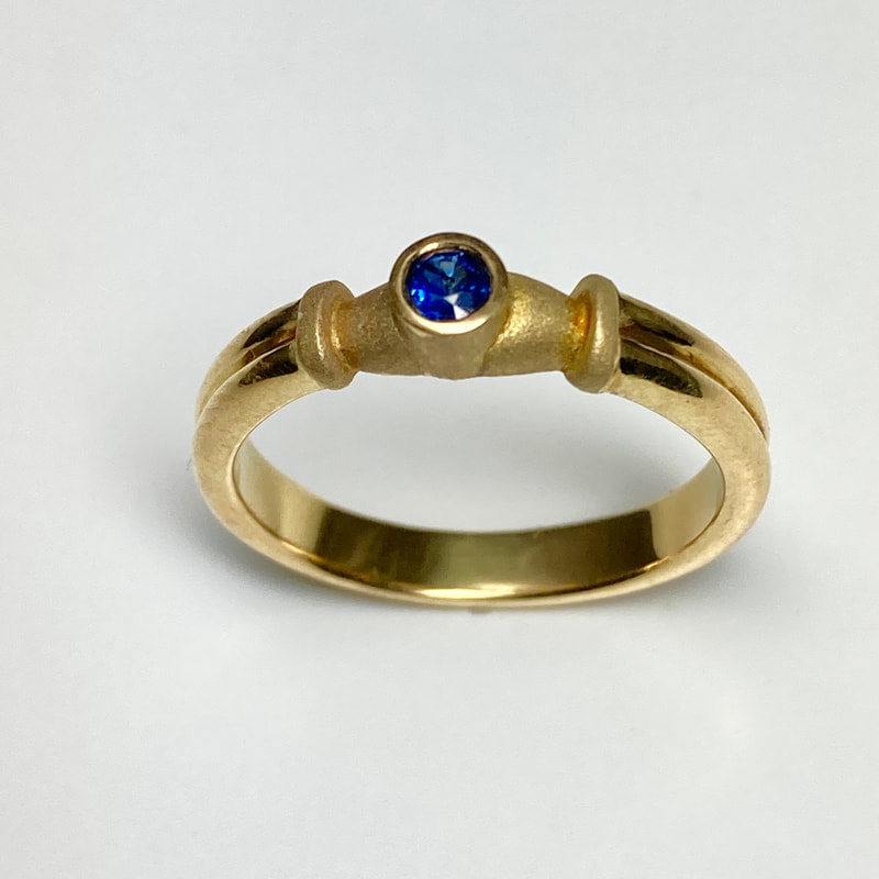 18 Karat Yellow Gold 3mm ring with Blue Sapphire.