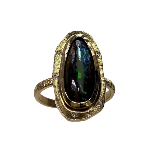 A gold ring with a natural elongated black opal and a border with spaced inset diamonds and a textured band.