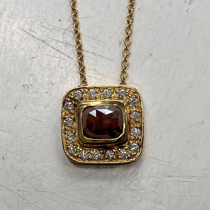 Yellow gold square pendant with a square natural red diamond surrounded with a halo of white diamonds.