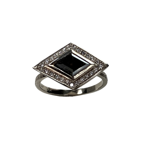White gold ring with a black diamond shaped diamond in the center with white diamonds tracing the outside, set east to west.