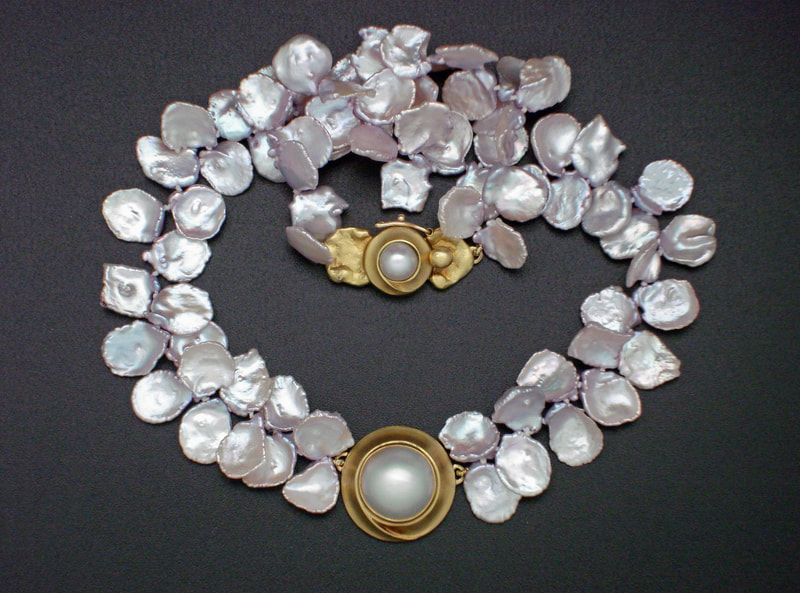 18 Karat Yellow Gold and 14 Karat Yellow Gold Freshwater flat pearls with a Mabe pearl in the center and on the clasp.