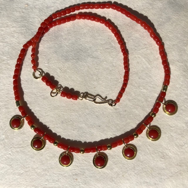 22K & 18K Yellow Gold Ox Blood Coral Necklace with 7 spaced round coral stations at the bottom.