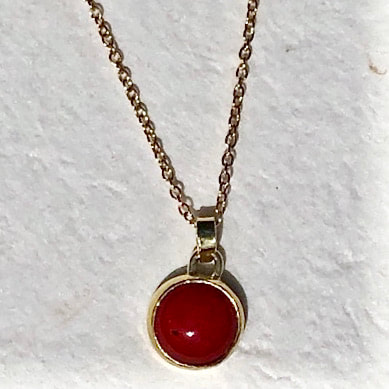 Gold pendant on a chain with Ox Blood Coral.