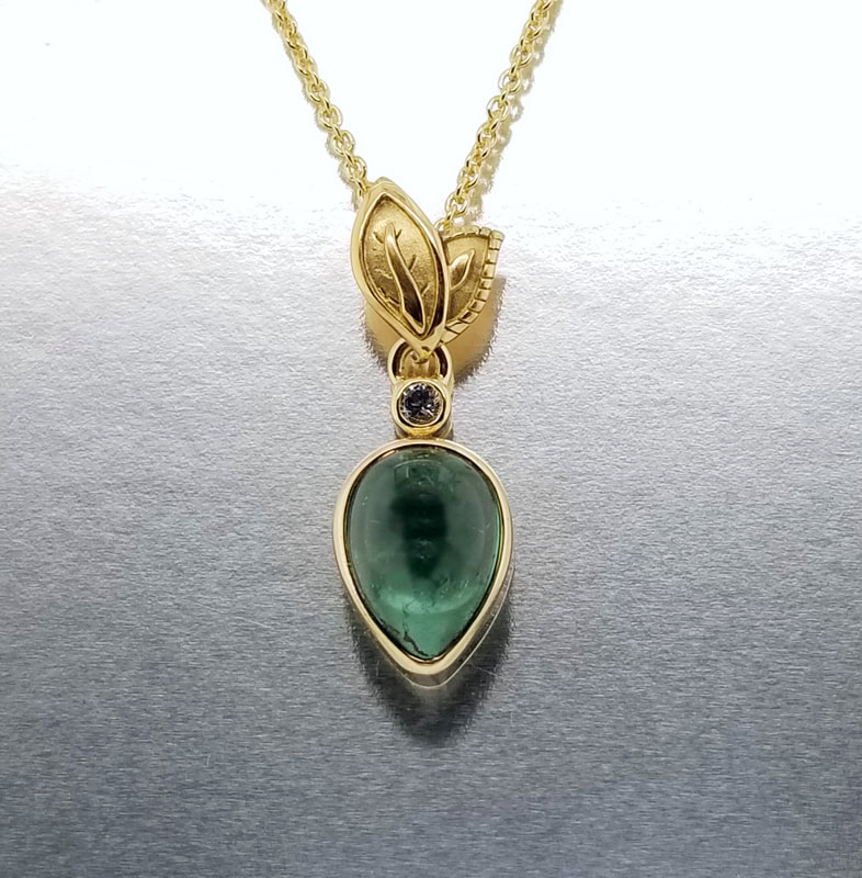 18 Karat Yellow Gold pendant with a pair shaped Green Tourmaline and Leaves.