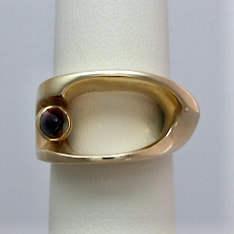 14 Karat Yellow Gold open ring with a small bezel - set bullet shaped Amethyst on one side.