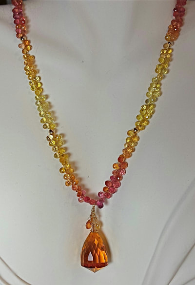 14 Karat Yellow Gold necklace with small tear drop shaped briolette Multi-Color Sapphires and a faceted acorn shaped Gold Quartz at the center.