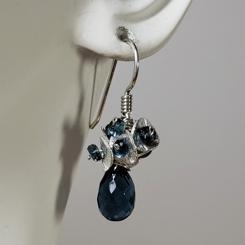 Sterling Silver French wire earrings with brushed silver discs with Blue Topaz clustered around the top of a tear drop briolette Blue Topaz.