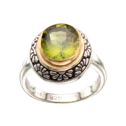 Sterling Silver ring with an 18 Karat Yellow Gold bezel set oval Peridot in the center surrounded with flower designs.