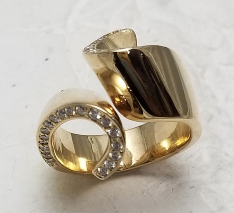 14 Karat Yellow Gold "Ribbon" Ring with diamonds on one edge of the band.