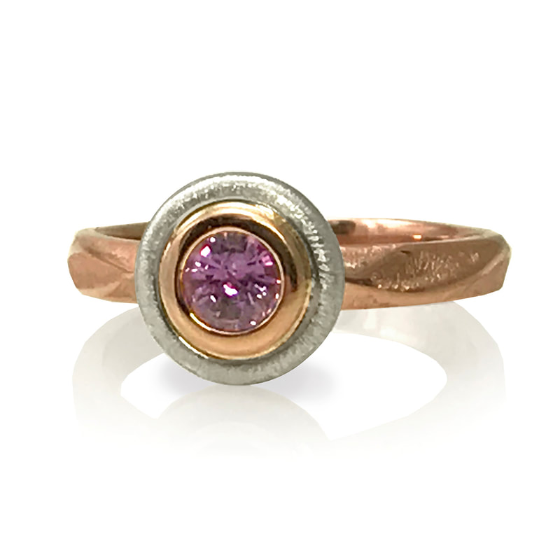 Rose and White Gold ring with Pink Sapphire in the center.