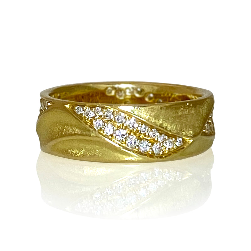 18 Karat Yellow Gold 6.5mm wide sculpted band ring with scattered diamonds diagonally across the top.