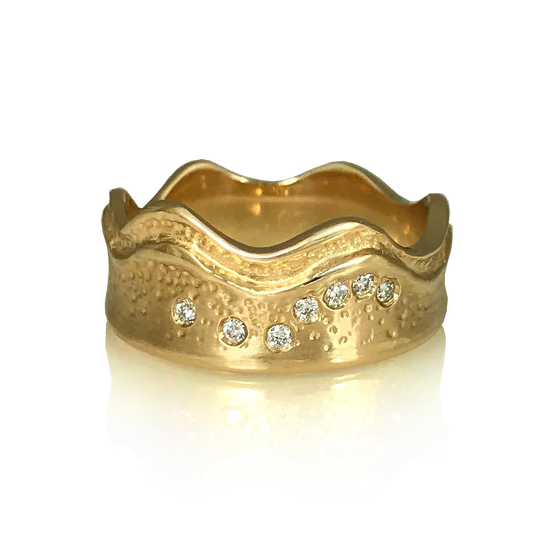 14 Karat Yellow Gold ring with one wavy side and one straight edge with diamonds.