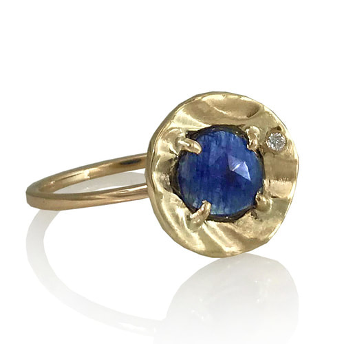 14 Karat Yellow Gold ring with a BlueSapphire in the center and one small diamond on the side.