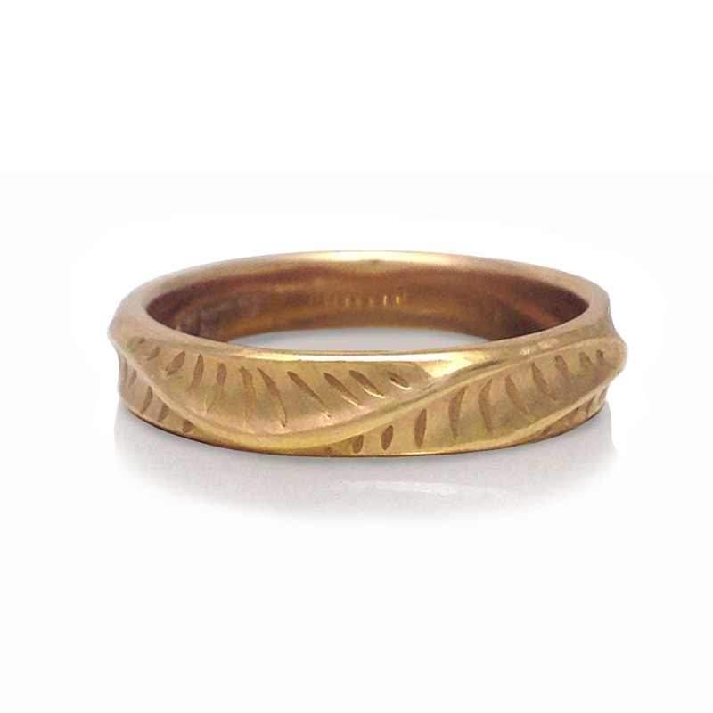 18 Karat Yellow Gold band with etched designs and curved details.