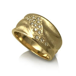 14 Karat Yellow Gold wide band ring with diamonds angled across the top and sculpted wave shapes.