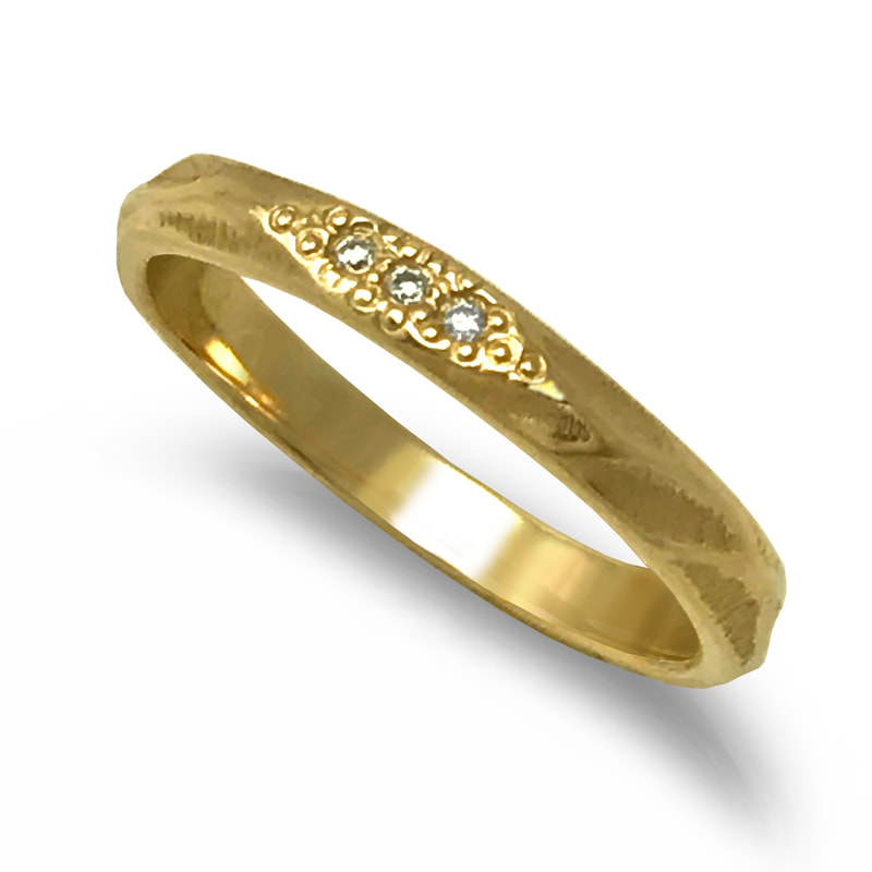 14 Karat Yellow Gold band ring with diamonds on the top and sculpted wave shapes and texture.