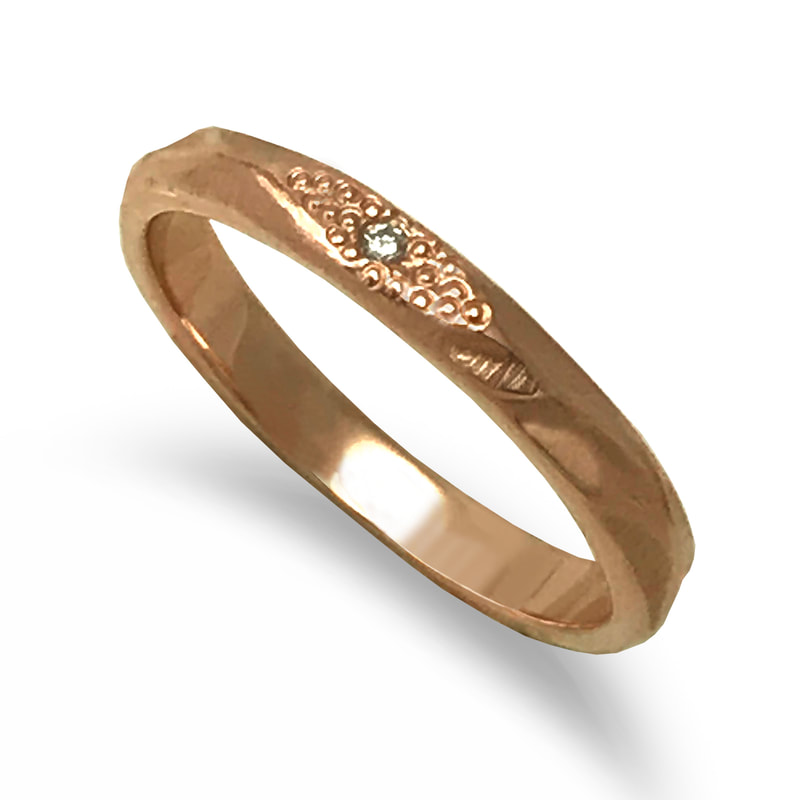 14 Karat Rose Gold thin ring with one small diamond on the top.