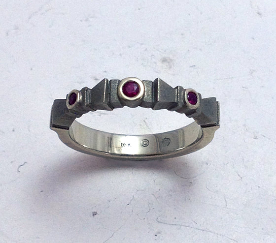 18 Karat White Gold ring with three Rubies on an angled band.