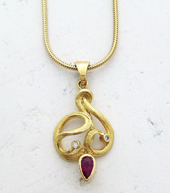  18 Karat Yellow Gold vine like Pendant with a Pear Shaped Ruby and Diamonds.