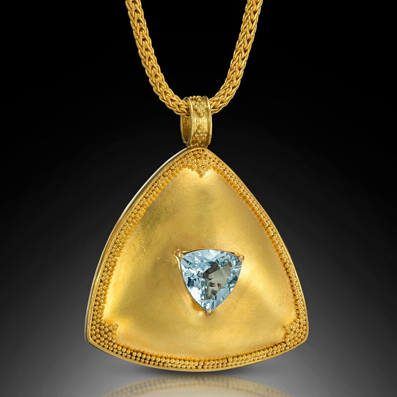 18 Karat Yellow Gold pendant with a trillion shaped Aquamarine and 22 Karat Yellow Gold granulation.