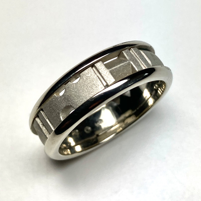 18 Karat White Gold Band with open cutout shapes in the center and high polish edges.