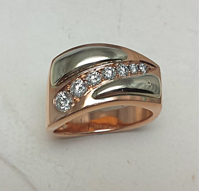 Rose gold and white gold left handed slant band with squared top and tapering diamonds.